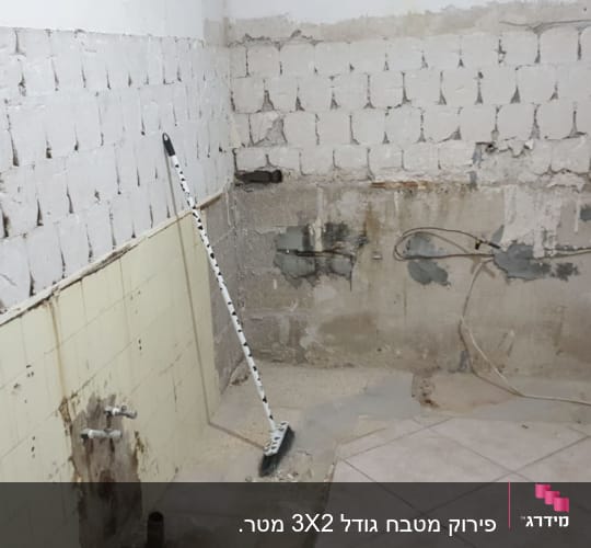 קיר חשוף עם בלוקים, מטאטא, חוטי חשמל חשופים